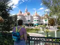 Dziewczyna z plecakiem w kształcie Myszki Miki patrzy na zamek w Disneyland Paris. Bilety do Disneyland Paris czekają na Ciebie!