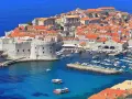 Dubrownik, Chorwacja. Marzysz o bezpośrednie loty do chorwacji? Tu cumują łodzie w turkusowej wodzie, a stare miasto kusi czerwonymi dachami.