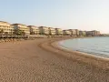 Piękna plaża z rzędami leżaków i białymi hotelami w tle, idealne miejsce na wakacje w Side Colakli.