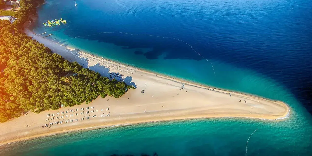 Piękna plaża w Chorwacji, idealne miejsce na wakacje. Zastanawiasz się, ile się leci do Chorwacji? Warto sprawdzić!
