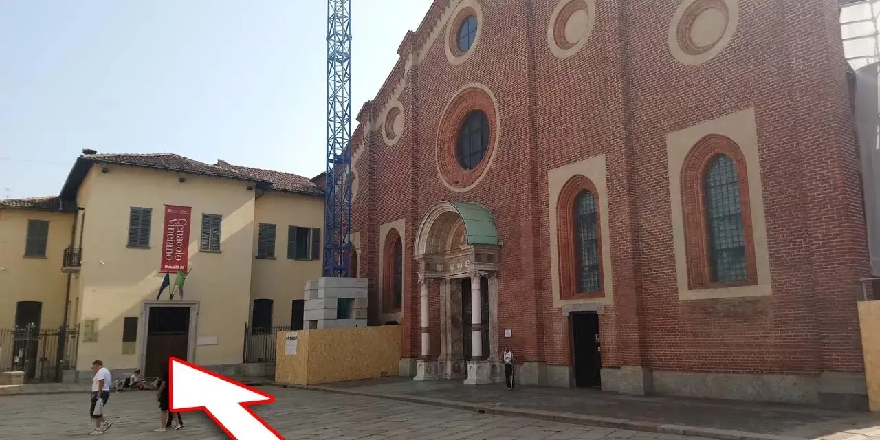 Plac przed kościołem z banerem "Cenacolo Vinciano". Bilety na Ostatnią Wieczerzę można kupić w pobliżu.