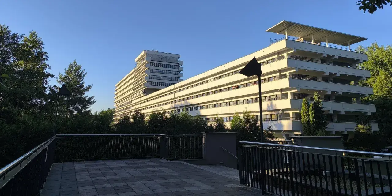 Nowoczesny budynek z tarasami, otoczony zielenią, idealny dla szukających najlepszych sanatoriów w Polsce.