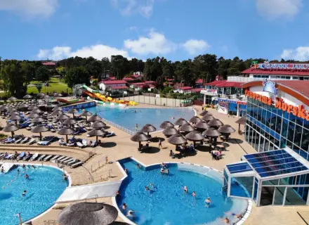 Aquapark w Jarosławcu: baseny, zjeżdżalnie i leżaki pod parasolami. Wiele osób korzysta z atrakcji, tworząc radosną atmosferę.