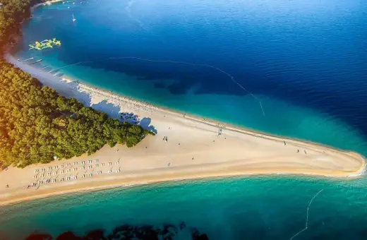Piękna plaża w Chorwacji, idealne miejsce na wakacje. Zastanawiasz się, ile się leci do Chorwacji? Warto sprawdzić!