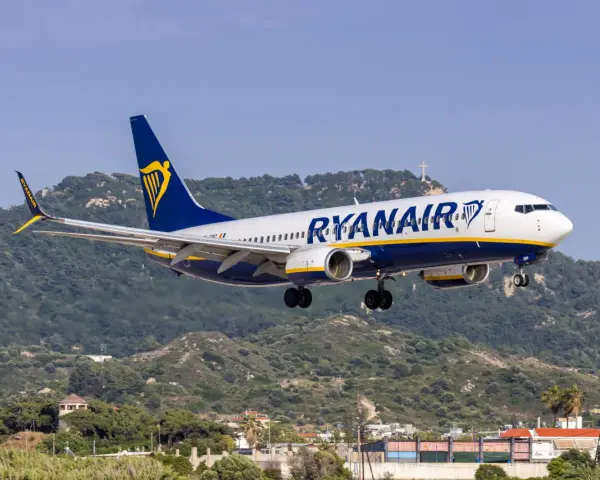 Ryanair ląduje na tle zielonych wzgórz i krzyża na szczycie.