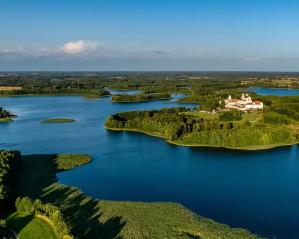 Malowniczy wschód Polski nad jeziorem, z wyspą i klasztorem.