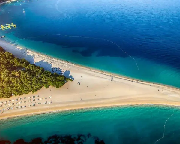 Piękna plaża w Chorwacji, idealne miejsce na wakacje. Zastanawiasz się, ile się leci do Chorwacji? Warto sprawdzić!