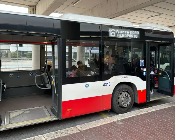 Autobus linii 16 do lotnisko w Bari czeka na pasażerów. W środku siedzą ludzie, drzwi są otwarte.