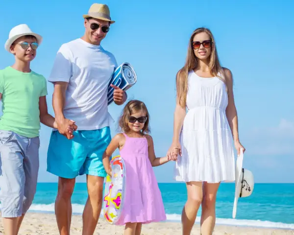 Rodzina na plaży, idealne miejsca na wakacje z dzieckiem. Słońce, morze i uśmiechy.
